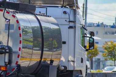 Şehir otobanındaki benzin deposunda. Kargo kamyonu. Şehir trafiği. Yakıt nakli. Nakliye aracı. Durmuş yol. Motorlu araçlar. Kargo taşıma işi.
