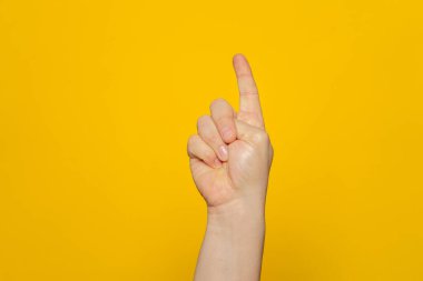 Hand shows index finger isolated on orange background, with clipping path, concept press the button first, double click the mouse, take the elevator
