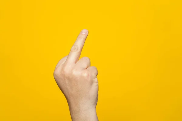 Finger hand symbols concept isolated sign of the middle finger in a gesture meaning fuck you or fuck off on yellow background