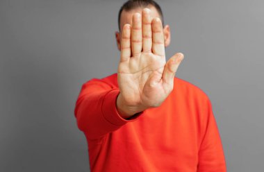 İspanyol adam fotoğraf makinesini durdurmak için elini öne atıyor. Gri renkli duvara karşı fotoğrafları veya görüntüleri reddediyor. Reddetme ve gizlilik kavramı