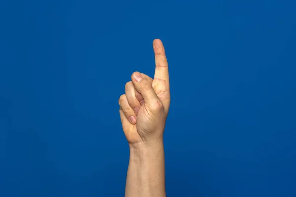Curious man hand with index finger up isolated on blue background, he has had a great idea and wants to explain it to everyone.