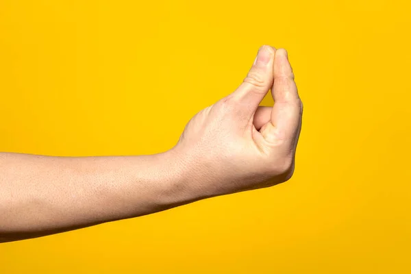 黄色の背景に隔離された Que Cosa顔のイタリアのジェスチャーを作る人の手のクローズアップ — ストック写真