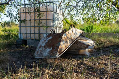 Tarlaya beton yığmak için kullanılan metal kapların görüntüsü, oksitlenmiş ve eski çünkü iç organlara yol açarlar.