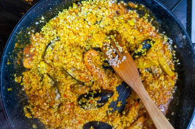 Geleneksel İspanyol deniz ürünleri paella 'sının hazırlıklarının yakın çekimi. Yukarıdan bak, düz yat