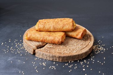                           Ahşap bir mutfak tahtasının üzerinde kızarmış börek..     