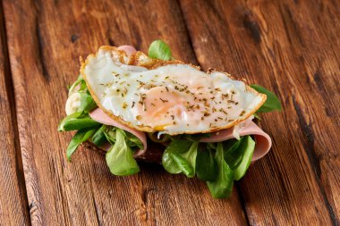                                Tahta masada kızarmış yumurta ve sosisli sandviç.