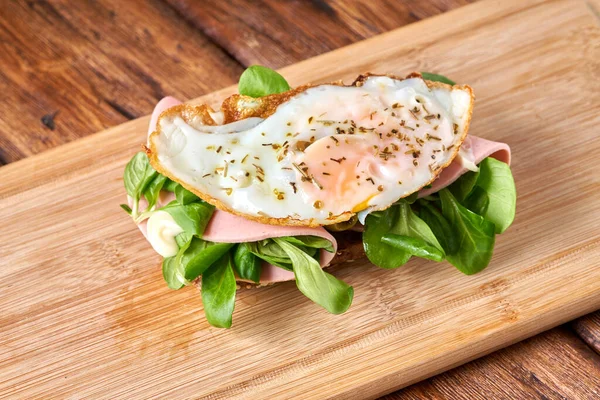 stock image                                Sandwich with fried eggs and sausage on a wooden table