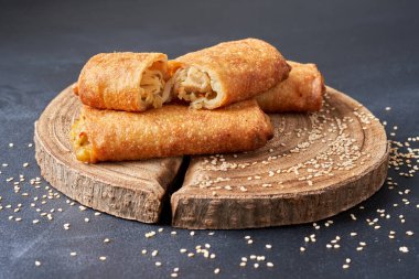 Ahşap bir mutfak tahtasının üzerinde kızarmış börek..                               