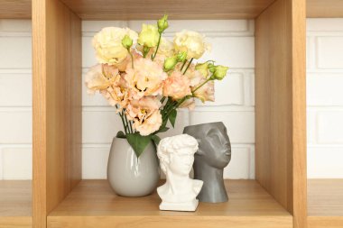 Tahta raf ve tuğla duvara karşı farklı eşyalar.