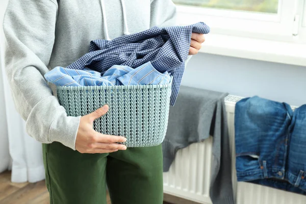 Woman holds basket with laundry, space for text