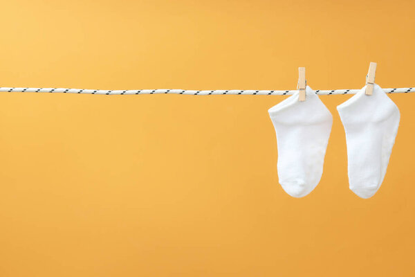 Socks hanging on twine on beige background