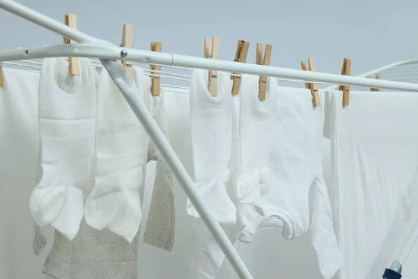 浅色背景的袜子和衣服烘干架 — 图库照片