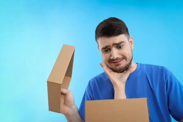 Mão Segurando Homem Olhando Uma Caixa Fundo Azul — Fotografia de Stock