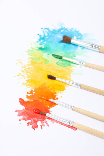 Paint brushes with paints on white background
