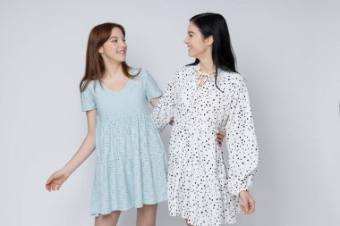 Two beautiful young women, sisters - twins on white background