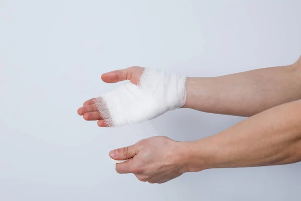 傷害の間の助けの概念 白い背景の包帯に手を包む男 — ストック写真