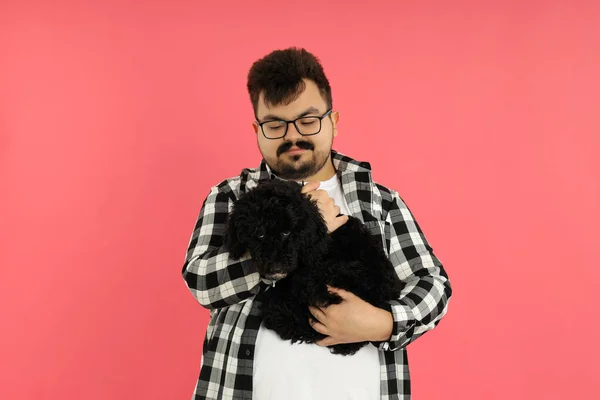 Concept of people, young fat man with dog on pink background