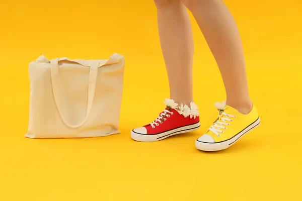 Weibliche Beine Und Baumwolltasche Auf Gelbem Hintergrund — Stockfoto