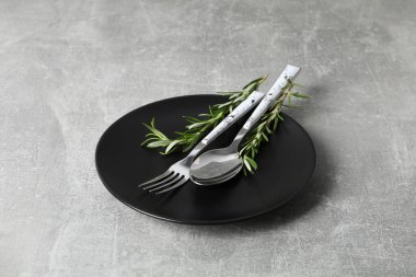 Gri desenli arka planda çatal bıçak ve biberiyeli tabak.