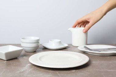 Kalıplı gri masa üzerinde boş tabak içeren en küçük tablo ayarı