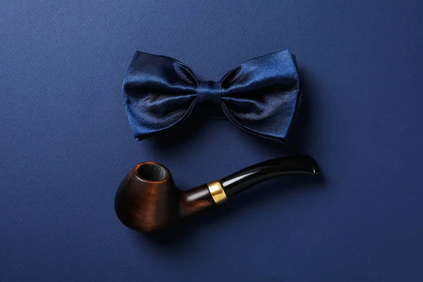 烟斗和蓝色背景的领带弓 — 图库照片