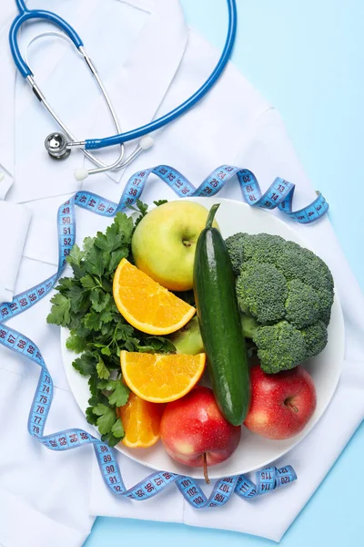Healthy food and doctors accessories on blue background - weight loss
