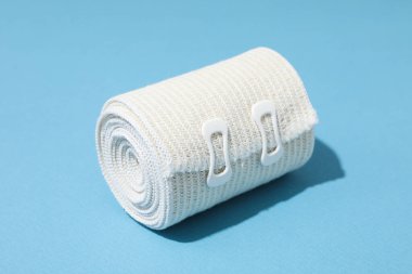 Yaralanma sırasında yardım kavramı, mavi arka planda elastik bandaj