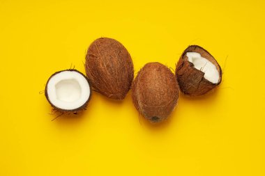 Sarı arka planda hindistan cevizleri, yaz konsepti için kompozisyon