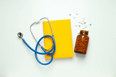 Tıp literatürü - beyaz arka planda kitap ve doktor aksesuarları