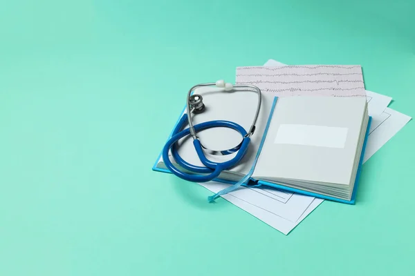 Medical literature - book and medical accessories on mint background