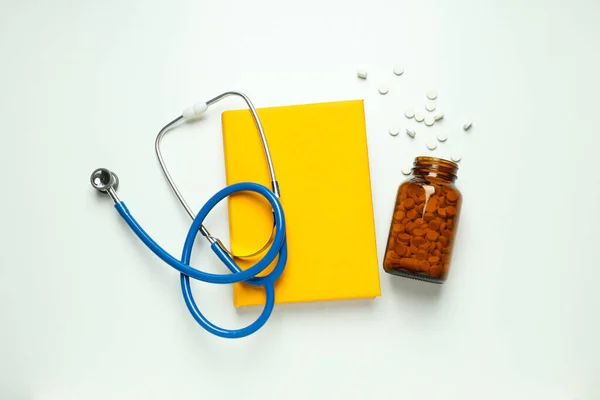 stock image Medical literature - book and doctors accessories on white background