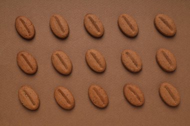 Concept of tasty snack for hot drink - cookies in the shape of coffee seeds