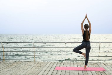 Yoga dışarıda genç bir kadınla, sağlık ve vücut bakımı konsepti