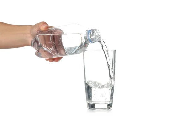 stock image Female hand pour water in glass from bottle, isolated on white background