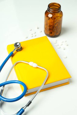 Tıp literatürü - beyaz arka planda kitap ve doktor aksesuarları