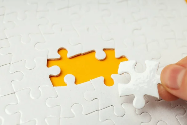 Puzzles Blancs Sans Deux Puzzles Sur Fond Orange Les Doigts — Photo