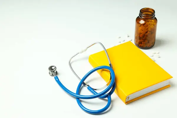 stock image Medical literature - book and doctors accessories on white background