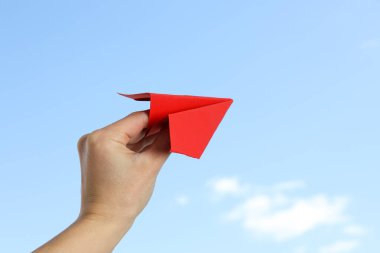 Gökyüzü zemininde kağıt uçaklı bir kadın.