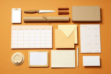 Bej arka planda bağımsız ofis aksesuarları ile Mockup düz yatıyordu