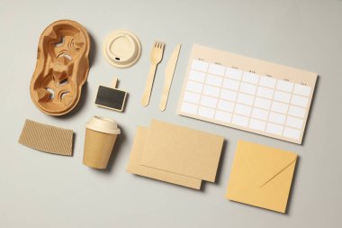 Açık gri arkaplanda el işi aksesuarları olan düz maket.