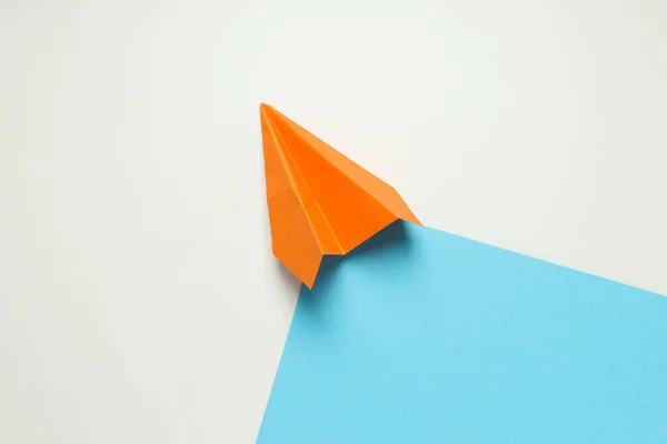Orange paper plane on white - blue background
