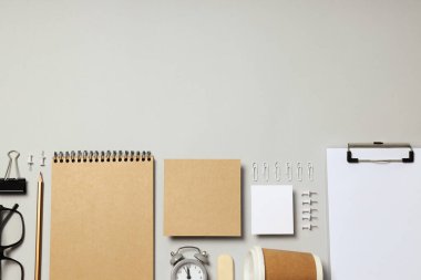 Mockup dairesi açık gri arka planda farklı ofis aksesuarları ile yatıyordu