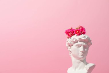 Pembe arka planda çiçekleri olan kadim bir kafa.