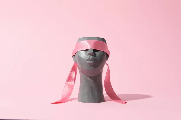ピンクの背景に目にリボンで装飾的な頭 — ストック写真