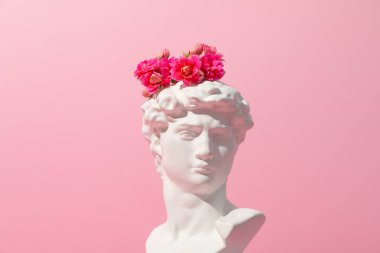 Pembe arka planda çiçekleri olan kadim bir kafa.