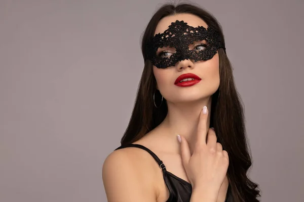 stock image Girl in a mask with red lips, on a gray background