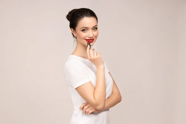 stock image The girl paints her lips with red lipstick