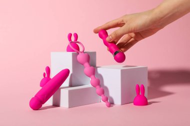 Pembe arka planda küpleri olan pembe seks oyuncakları kompozisyonu