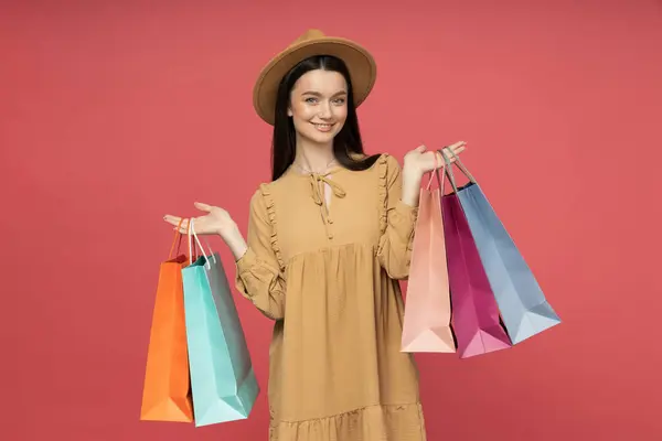 ショッピングバッグを持つ若い女性 ピンクの背景に — ストック写真