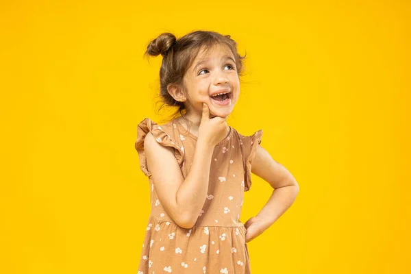 Malá Holčička Přemýšlí Žlutém Pozadí — Stock fotografie